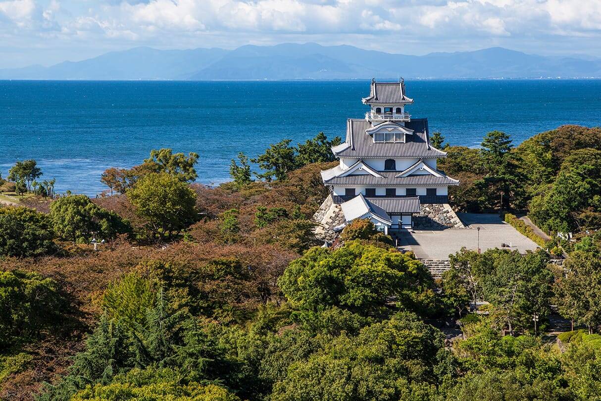 長浜城の美しい風景が広がる画像。青空の下、歴史的な城が堂々とそびえ立つ様子が描かれている。