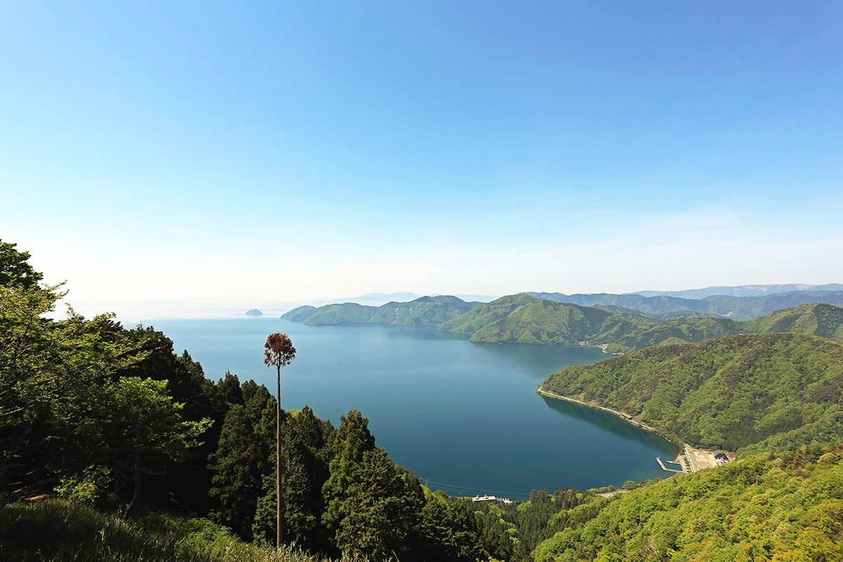美しい湖の風景。静かな水面に山々が映り込み、穏やかな自然の雰囲気が広がる。